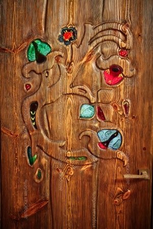 Fragment of a door with a carving and stained-glass windows